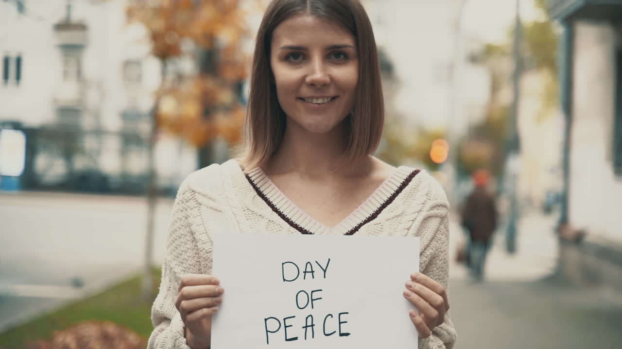 평화의 날. 밖에서 표지판을 들고 있는 젊은 여성.