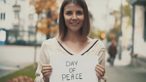 día de la paz. mujer joven con un cartel afuera.