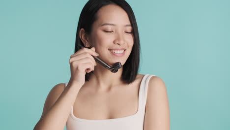 asian woman massaging her face.