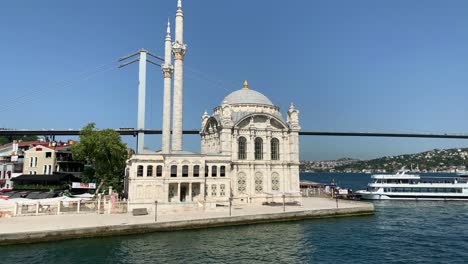 footage of historical mosque landmark called "ortakoy", bridge, cruise tour boat and bosphorus strait in istanbul. beautiful scene.