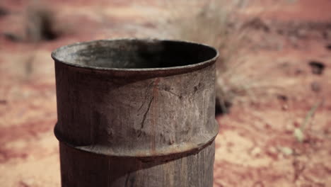 old empty rusted barrel on sand