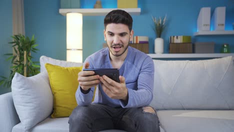 man watching video on smartphone alone at home.