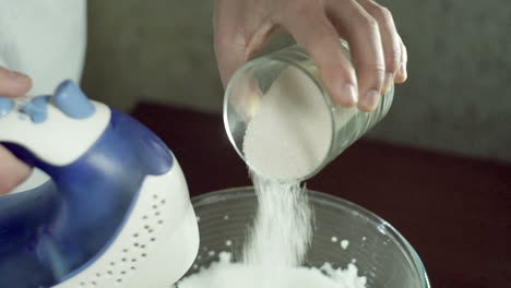 sugar pouring from glass to mixing bowl. baking ingredients. cooking sweet food