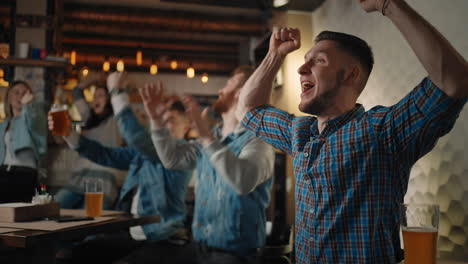 Cheering-young-men-drinking-beer-and-watching-sport-game-in-the-pub.-Watch-basketball-hockey.-The-scored-puck.-Fans-in-the-pub