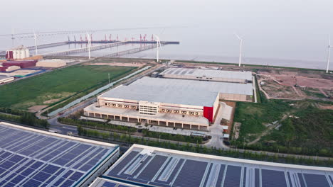 Aerial-Shot-of-Warehouse-Shipping-Center-with-Windmills-in-the-Background