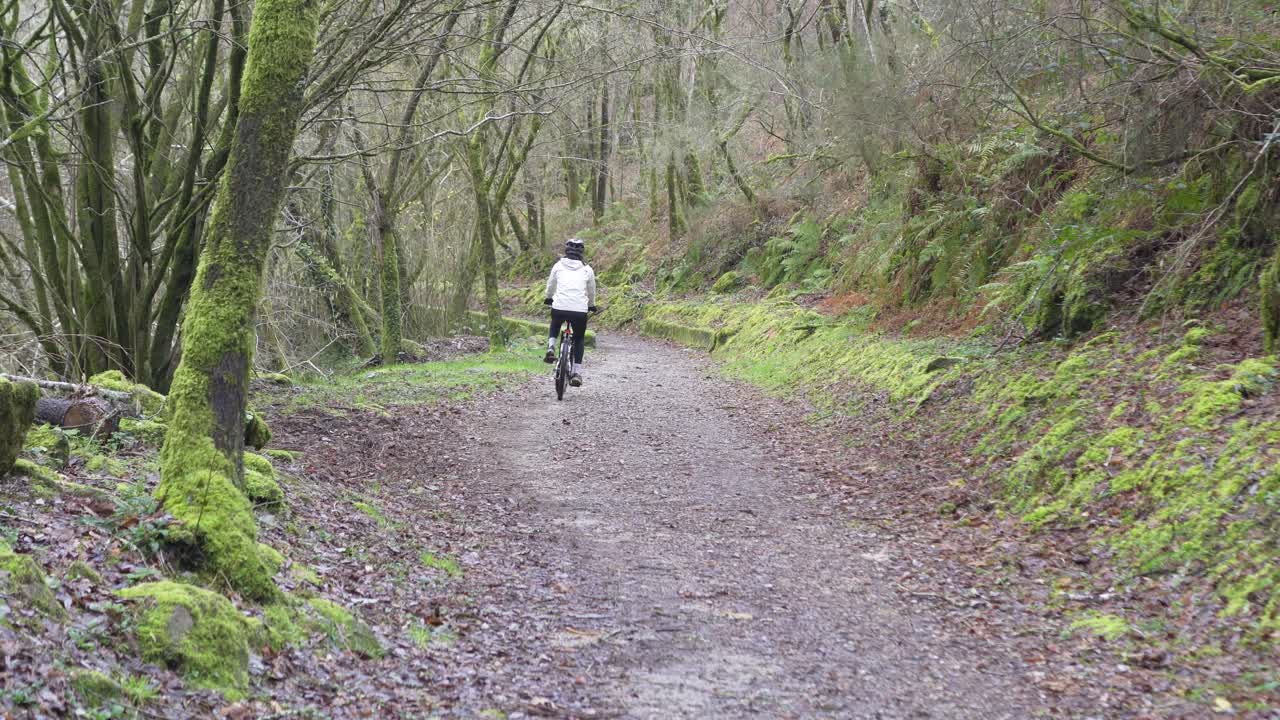 Girl pedaling a bike calmly along a path surrounded by lush green nature. Calm, fun and healthy living
