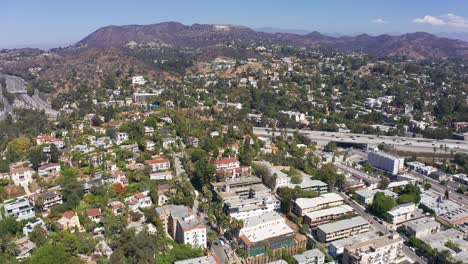 High-panning-aerial-shot-of-Highway-101-through-the-Cahuenga-Pass-in-Los-Angeles,-California