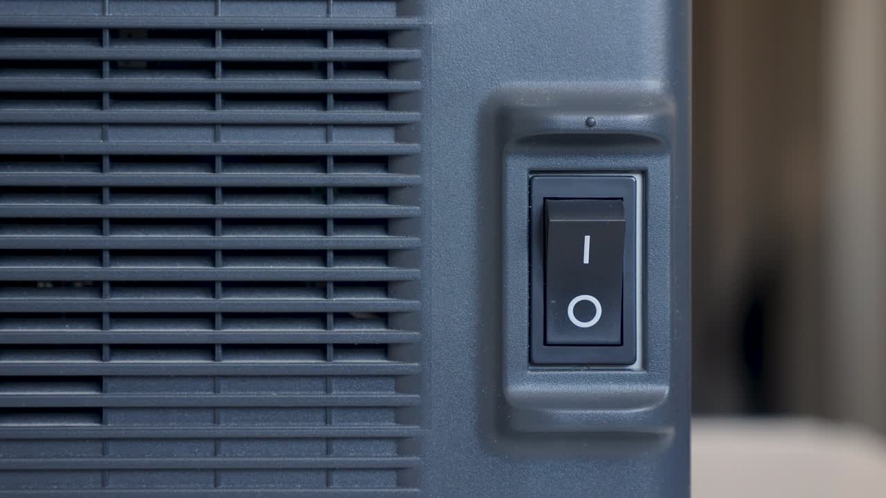 el dedo de una persona presiona se enciende y se apaga en un botón de plástico negro