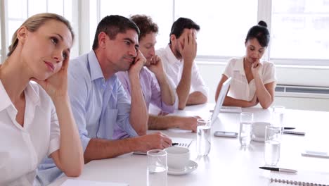 Bore-business-team-sitting-around-the-table-