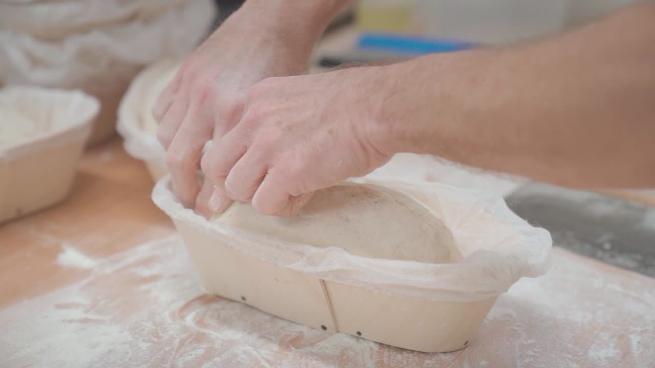 Forming the loaf of bread from wheat dough in a bakery