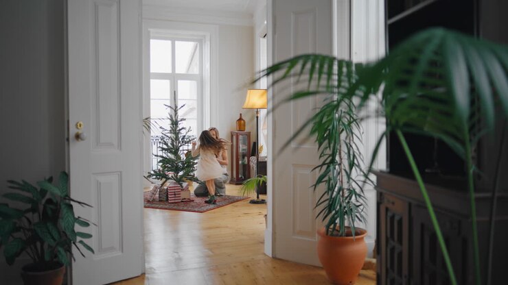 Happy mother daughter decorating Christmas tree home. Family preparing New Year
