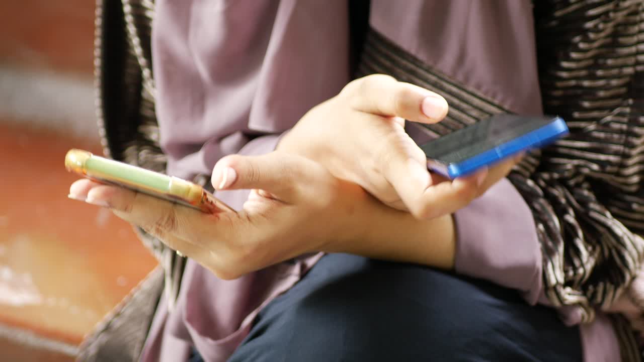 mujer usando dos teléfonos inteligentes