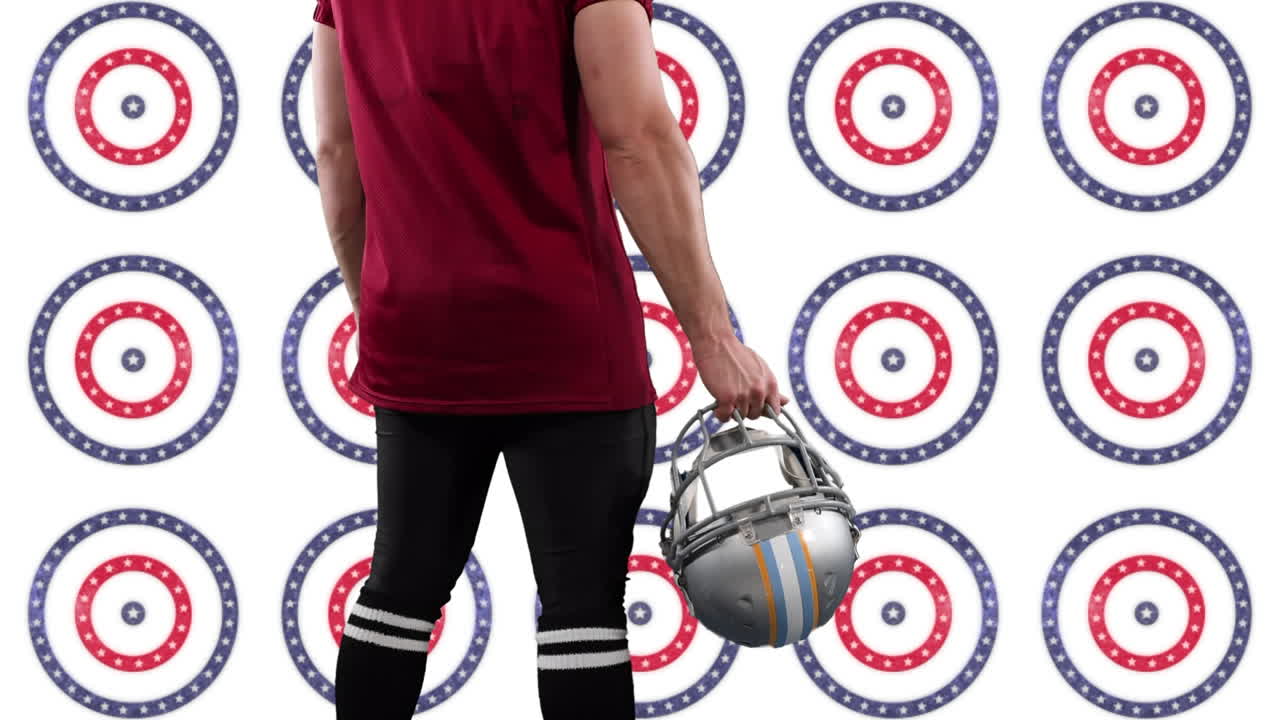 럭비 선수 의 중간 섹션 은 헬 ⁇  을 들고 회전 하는 원 에 있는 여러 별 들 에 대항 하여 서 있다