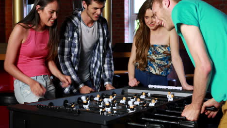 happy friends playing table football