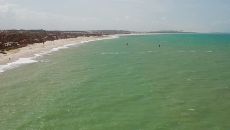 antena: cumbuco durante el día con gente haciendo kitesurf