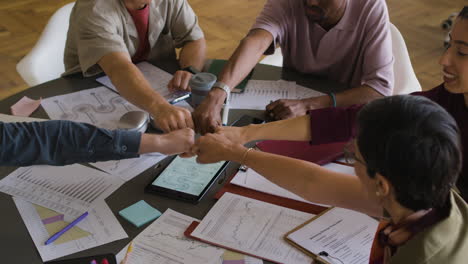 diverse business team doing a fist bump in a meeting