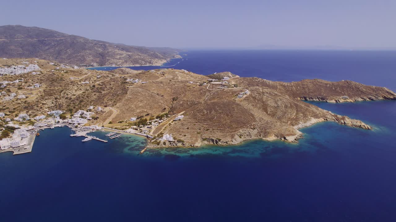 Aerial view of a picturesque Greek island village and harbor with clear blue waters