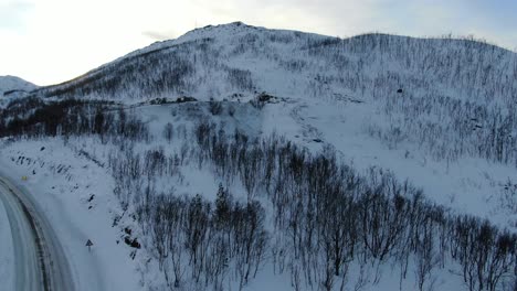 Drohne-Hebt-Sich-Vom-Boden-Mit-Blick-Auf-Die-Tromsø-Berge-Im-Winter-Voller-Schnee-In-Norwegen