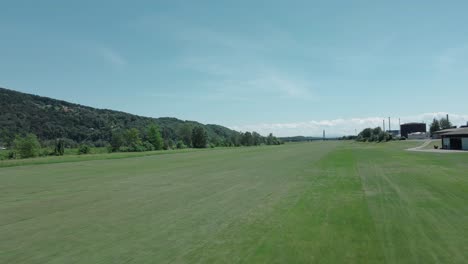 small piston engine aircraft landing on a grass strip at an airfield