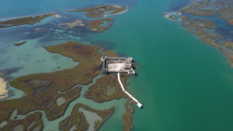 lagoon's secret sentinel: discovering a hidden fortress with stone walls embraced by tranquil waters near butrint's archaeological site