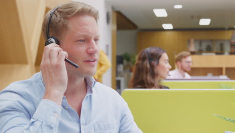 Hombre-De-Negocios-Usando-Auriculares-De-Teléfono-Hablando-Con-La-Persona-Que-Llama-En-El-Centro-De-Servicios-Al-Cliente