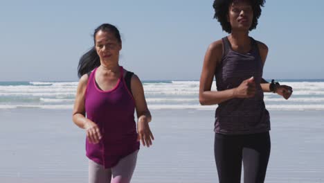 Multiethnische-Gruppe-Von-Frauen,-Die-Am-Strand-Und-Im-Hintergrund-Des-Blauen-Himmels-Laufen