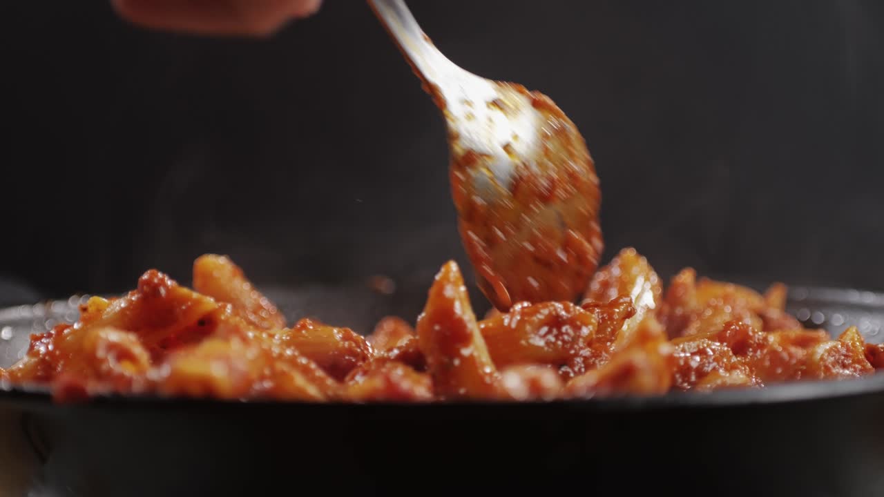 Cooking traditional arrabbiata pasta, penne with tomato sauce close-up. Cook classic homemade Italian tomato sauce for pasta and pizza in the pan. Chef cooks traditional Italian food. High quality 4k footage