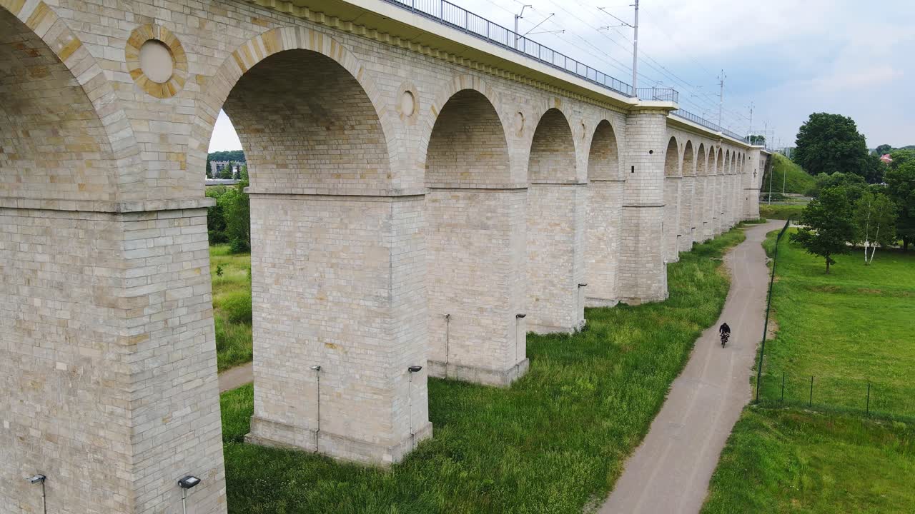 Poland’s Most nad Bóbr viaduct towers over countryside path as cyclist rides by