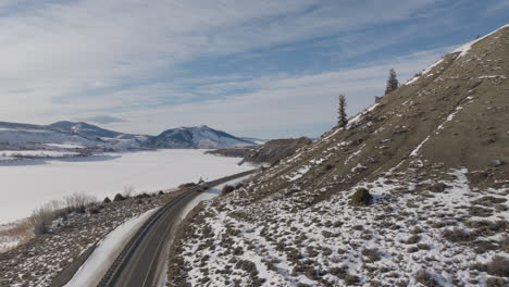 aerial shot of cars driving down a moutain road