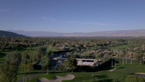 aerial view of a beautiful golf course with palm trees and mountains