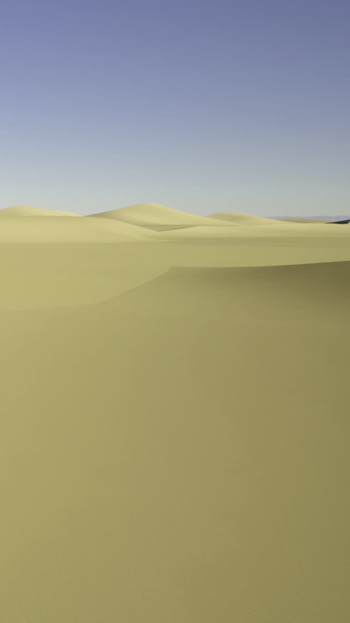 Vasto paesaggio desertico con dune sabbiose sotto un cielo azzurro e limpido.
