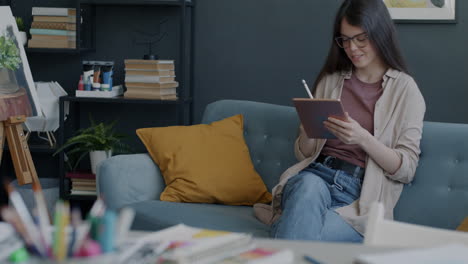 woman using tablet in home art studio