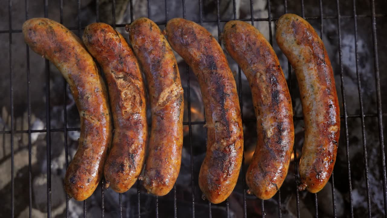 deliciosas salchichas jugosas, cocinadas en la parrilla con un fuego.