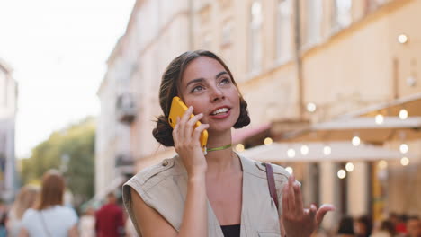 mujer feliz teniendo conversación remota hablando en teléfono inteligente buenas noticias chismes en la calle de la ciudad
