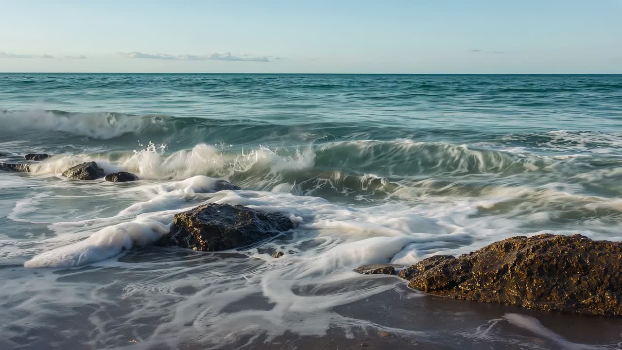 Surging swell pushing foam, curling over barnacled rocks at shoreline, creating backwash patterns