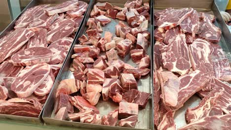 slices of frozen beef neatly arranged on a tray in a supermarket. ready for purchase, the meat is displayed under bright lighting, emphasizing its freshness and quality.