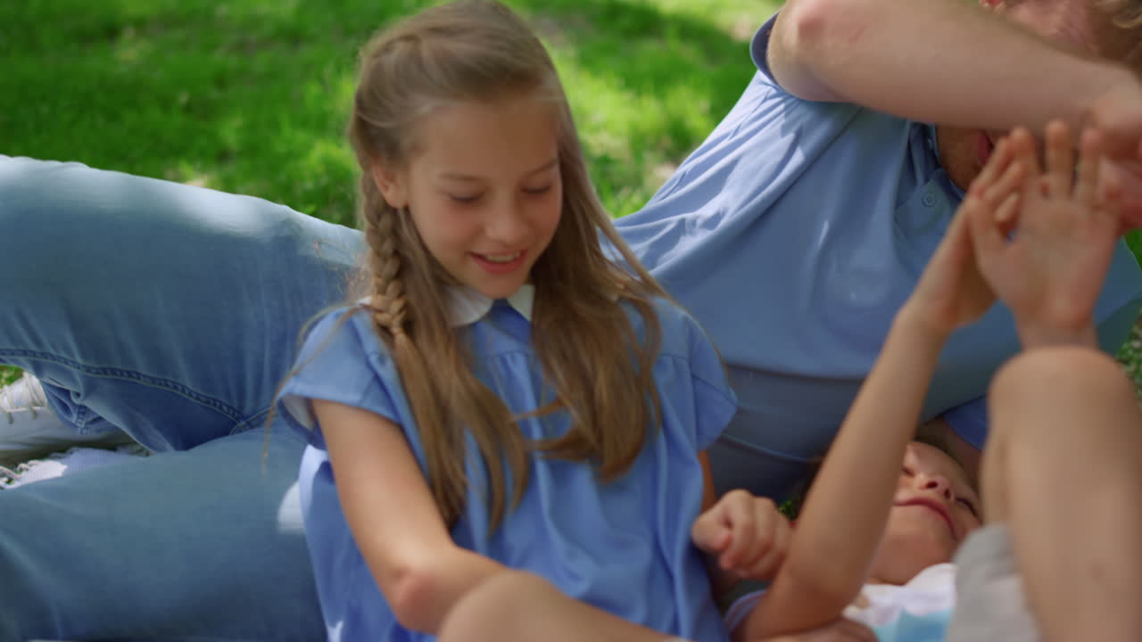 웃는 아버지, 피크닉 담요에서 아들을 걱거리는 부모, 아이들과 놀는 부모.