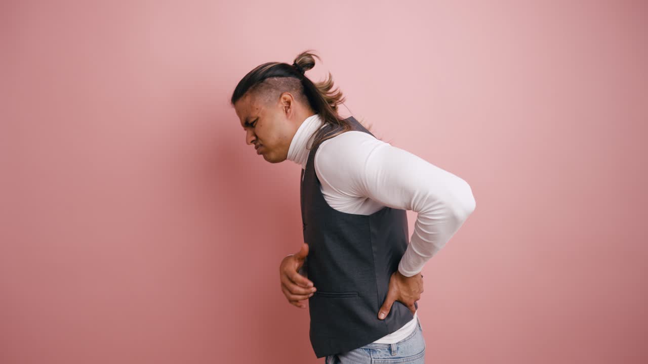 Man Experiencing Stomach and Back Pain in Studio