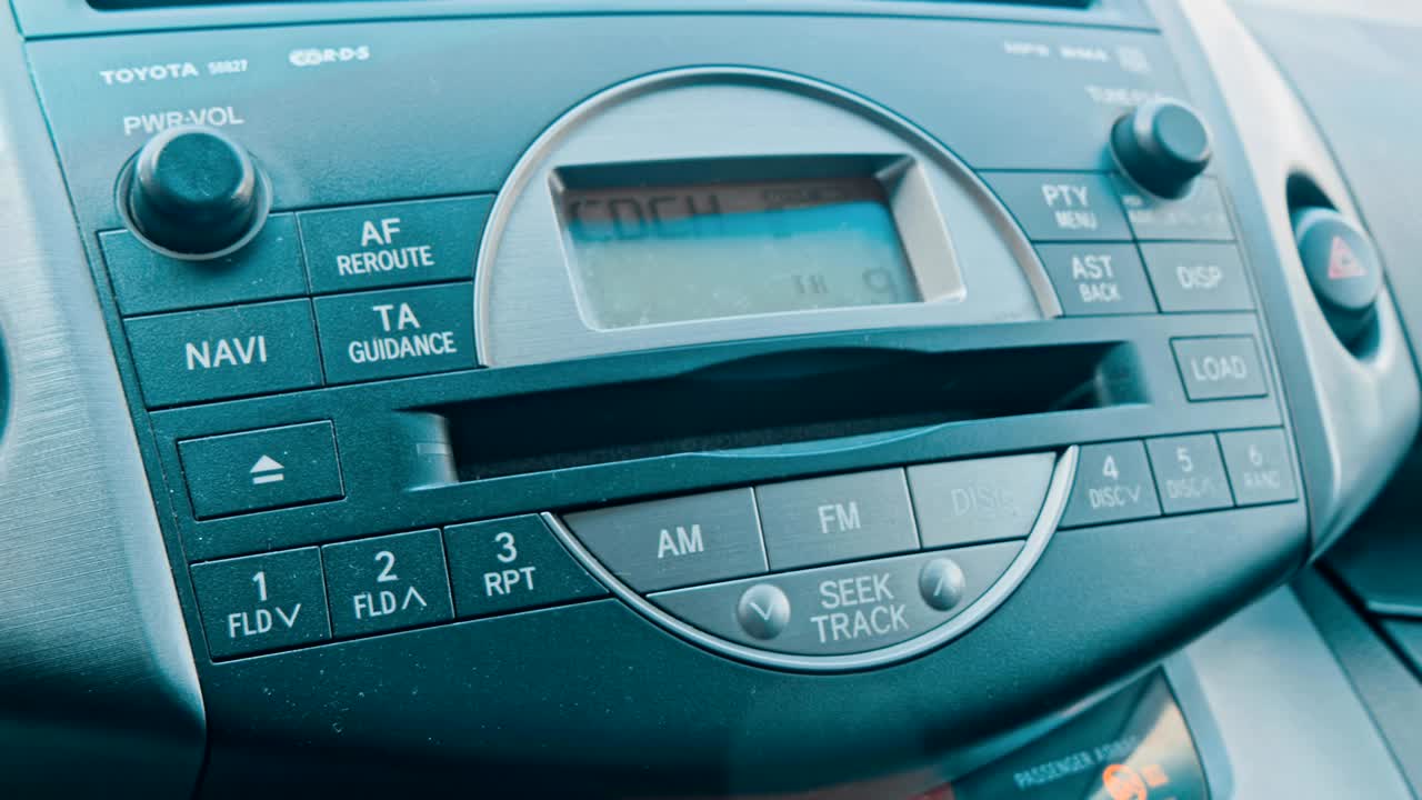 hombre que usa el sistema estéreo de audio del automóvil