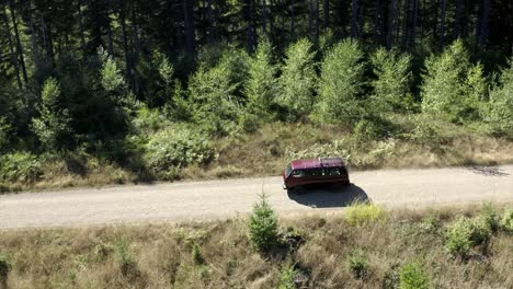 vw van vintage van driving through forest aerial view 4k drone