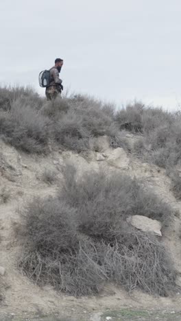 man with backpack in arid landscape