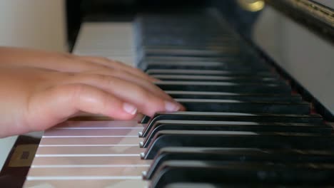 young girl learning to play the piano close up on hands and fingers