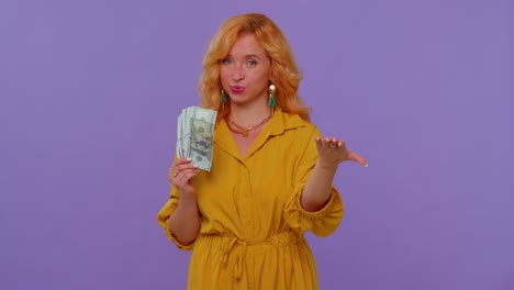 proud arrogant rich stylish girl holding money cash in dollars banknotes, smiling, looking at camera