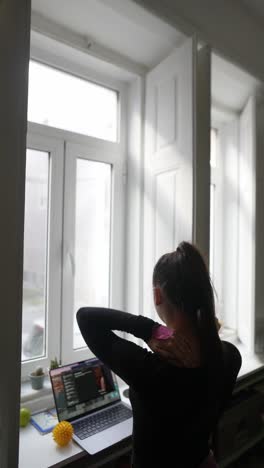 woman working from home or taking an online class near a window