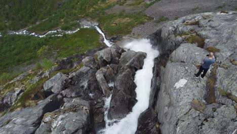 Tourist-standing-on-edge-of-steep-and-dangerous