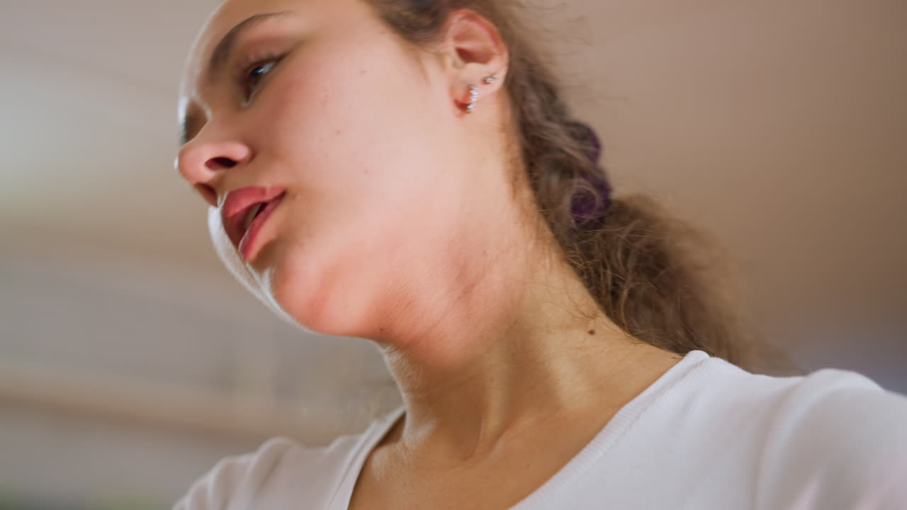 Portrait view of lady massaging cheeks with blue towel after workout showing tiredness, recovery and relief with closed eyes expression reflecting exhaustion, refreshment and relaxation