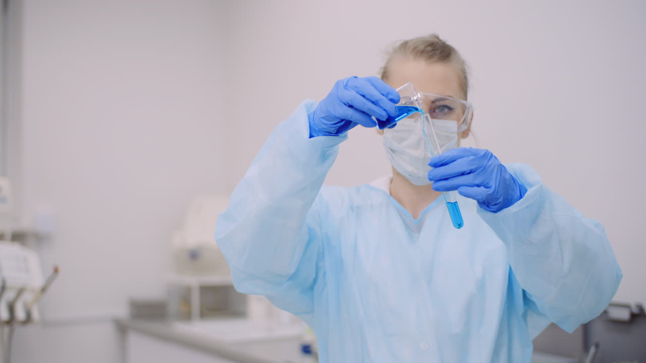 женщина-ученый держит в руках пробирки и колбу с жидкостью