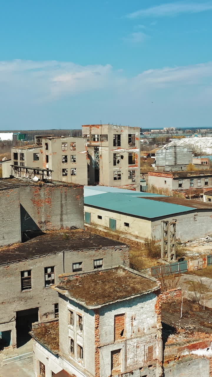 Vista aerea di una vecchia rovina di fabbrica e finestre rotte. Vecchio edificio industriale destinato alla demolizione. Video verticale.