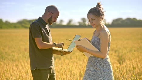 agronomists working in wheat field. agriculture scientist using computer