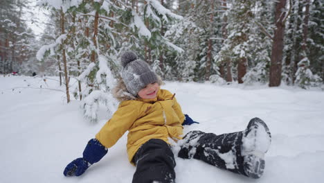 Kleines-Kind-Suhlt-Sich-Im-Schnee-Und-Hat-Spaß-Im-Winterwald,-Glückliche-Und-Unbeschwerte-Kindheit